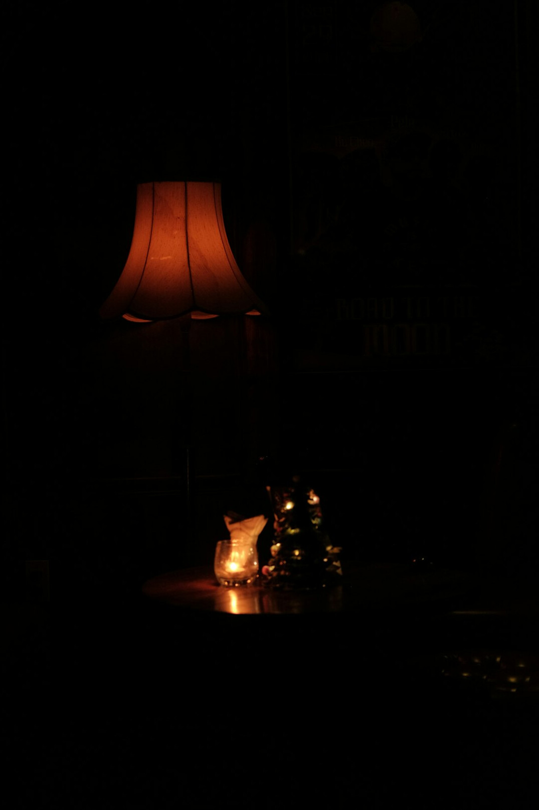 Warm lit desk with bookshelf, typewriter and notebooks in a dark study
